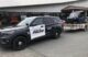 A black and white Lewiston Police cruiser sits outside a local business during a community event.