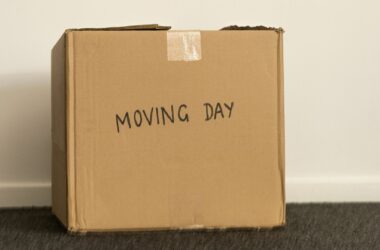 A brown cardboard box with "moving day" scribbled on the side in sharpie.