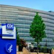 Exterior of the US CDC headquarters, including a large blue sign that features the CDC logo, the Department of Health and Human Services logo and reads Centers for Disease Control and Prevention Edward R. Roybal Campus.
