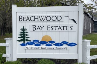 A white sign at the entrance to the condo complex that reads Beachwood Bay Estates.