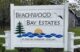 A white sign at the entrance to the condo complex that reads Beachwood Bay Estates.