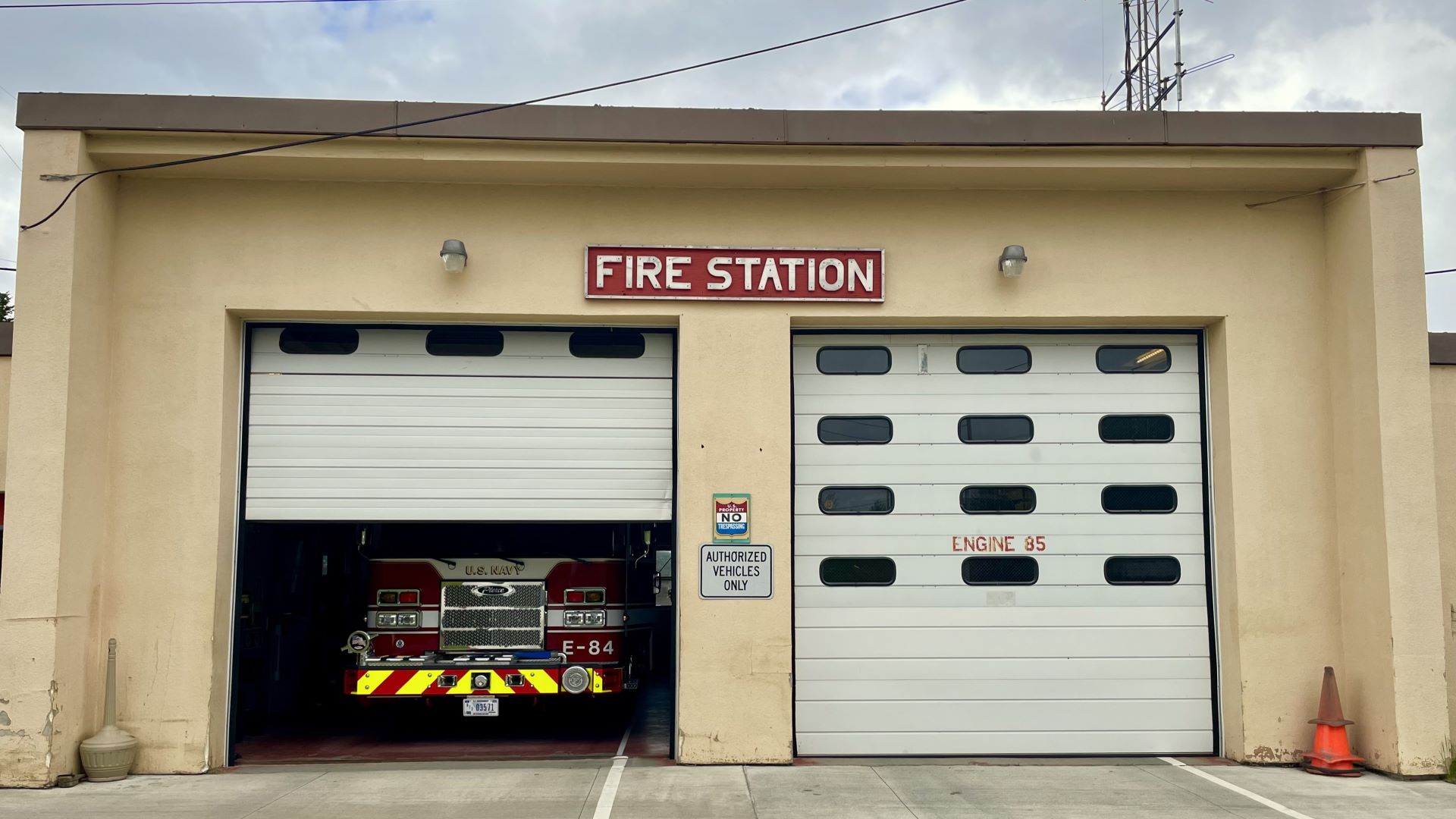 Exterior of the Cutler Fire Station with two doors to truck bays shown. One of the door is partly lifted up to show a fire truck inside the bay.