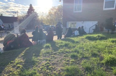 New asylum seekers sit on a lawn in Sanford, Maine.
