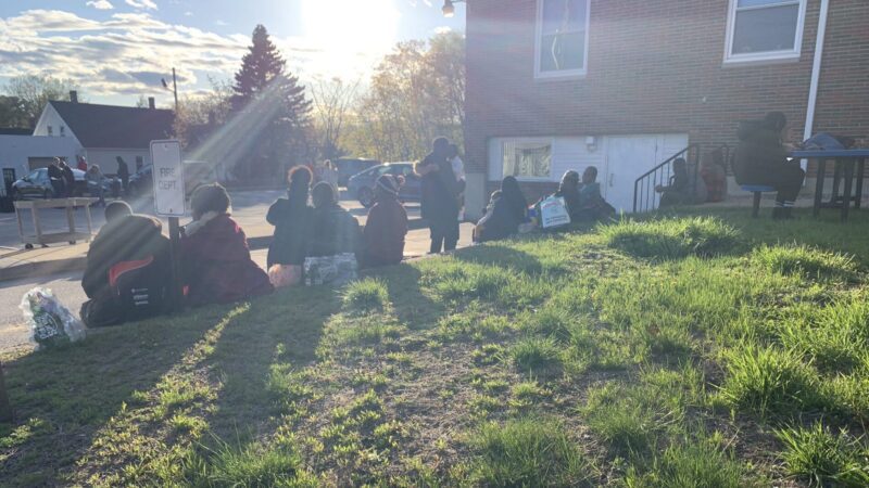 New asylum seekers sit on a lawn in Sanford, Maine.