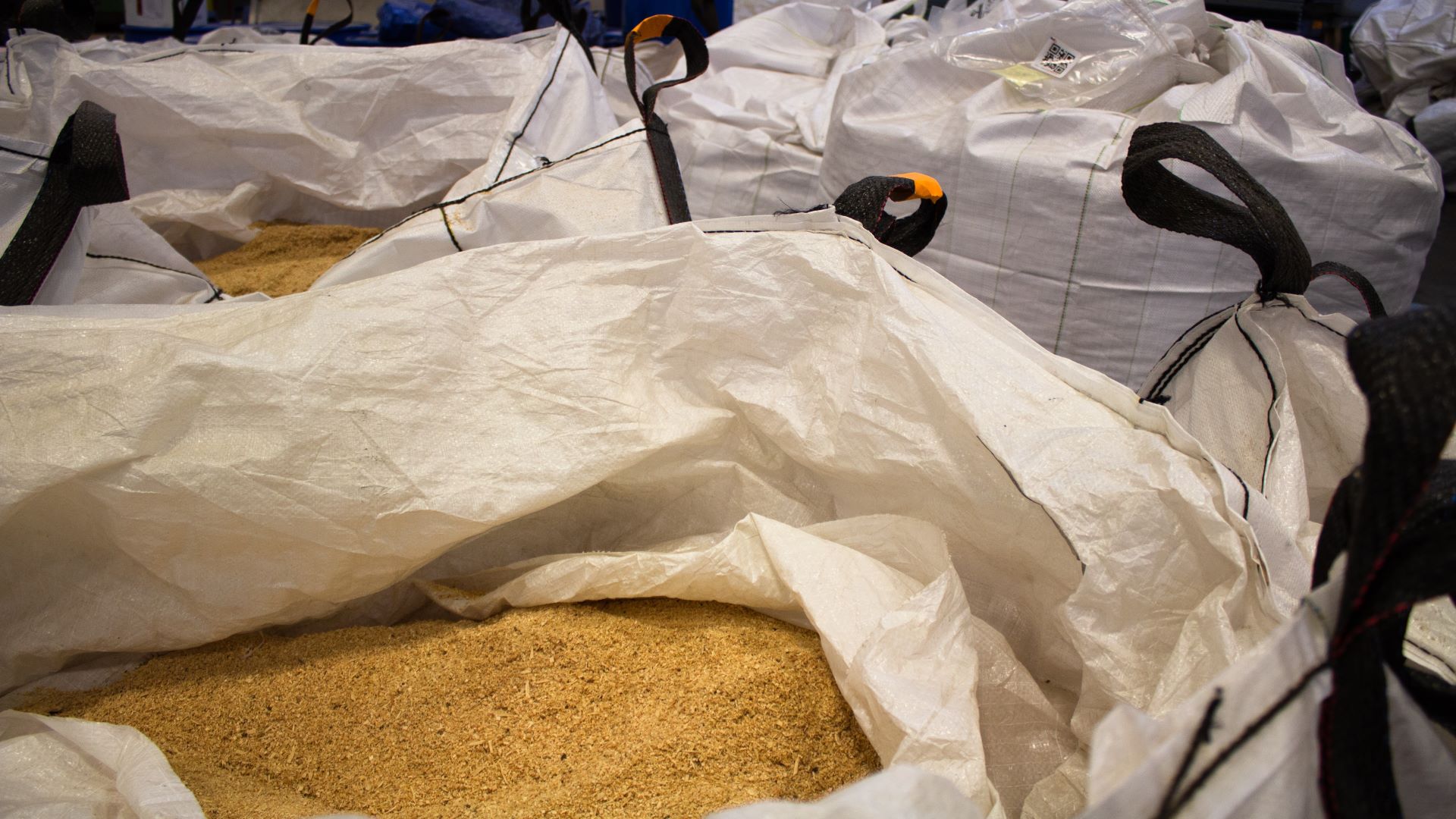 Large opened white sacks of sawdust.