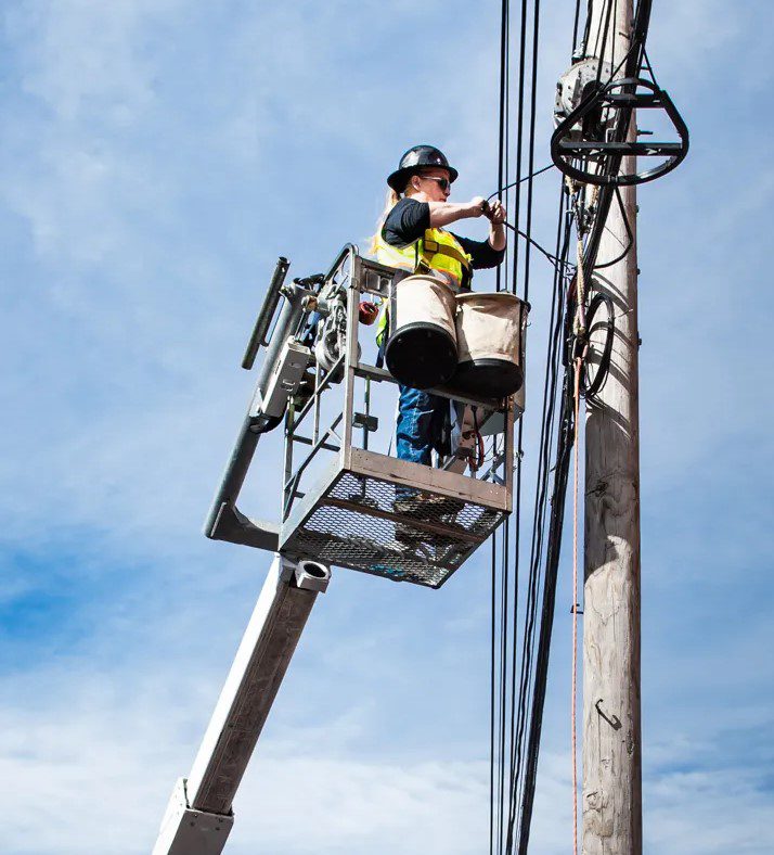 Heidi Leighton works on a fiber optic line while in a lift bucket.