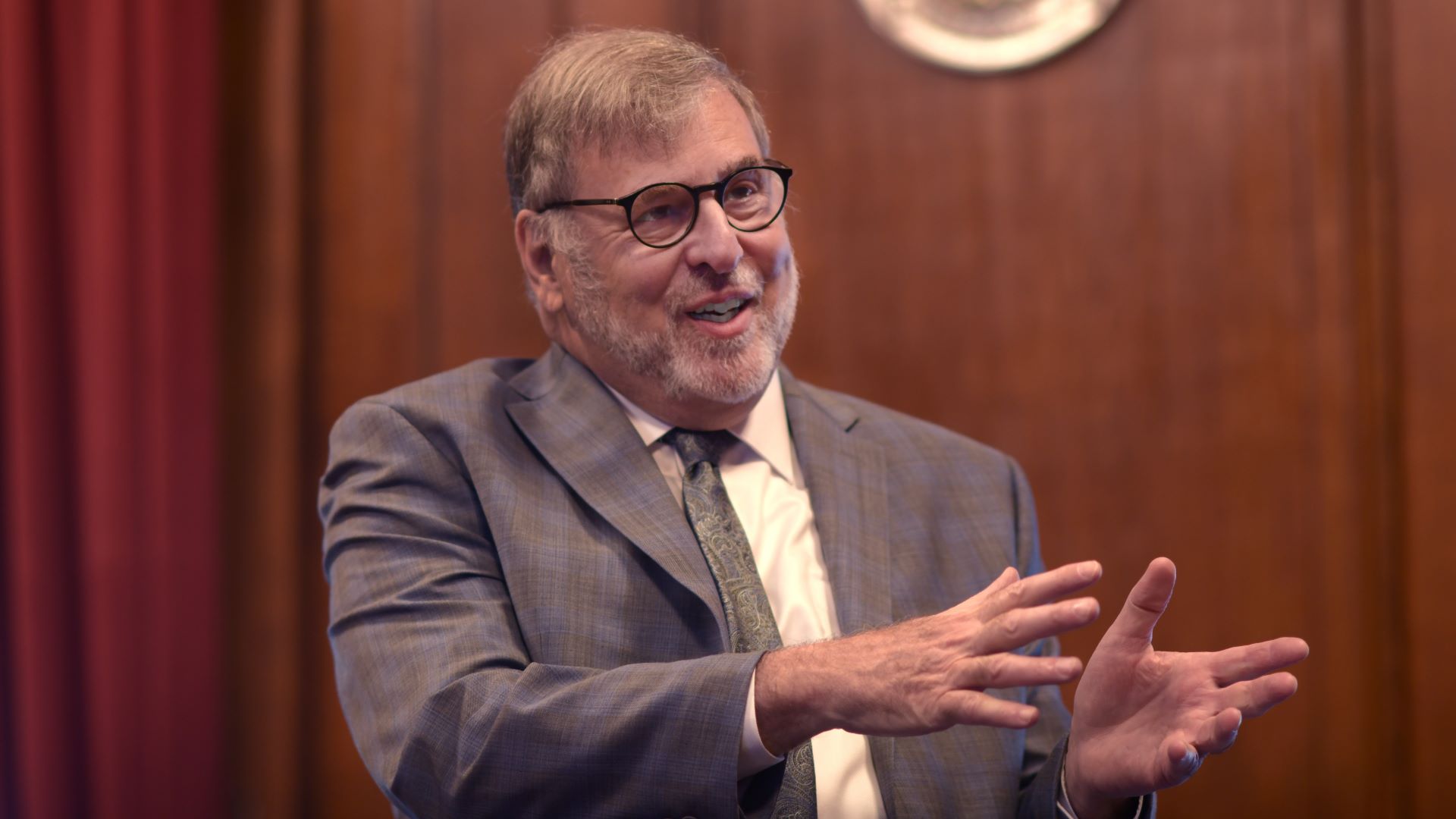 Judge Paul Aranson motions with his hands while speaking to an individual off-camera.