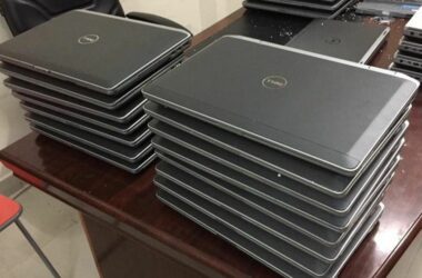 A stack of closed laptops on a desk.