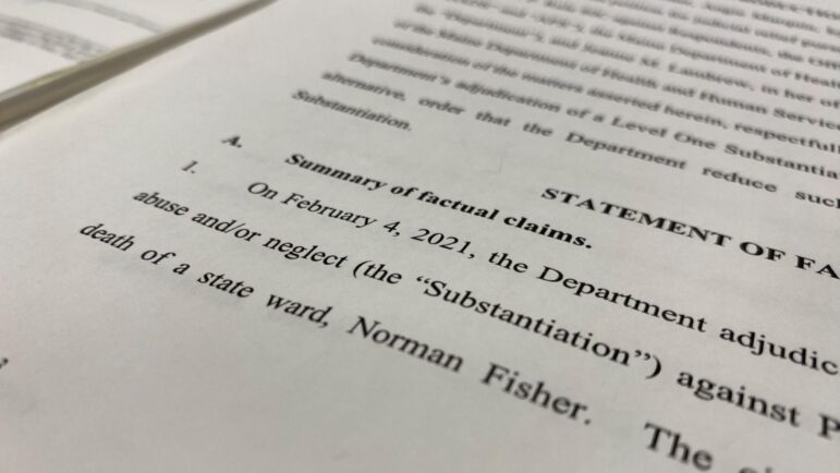 A cropped photo of a report involving the death of Norman Fisher. The photo was taken and cropped so as to not sure the entirety of the document. Among what is visible is: "Summary of factual claims. On February 4, 2021, the Department (unreadable) abuse and/or neglect, the substantiation, against (unreadable) death of a state ward, Norman Fisher."