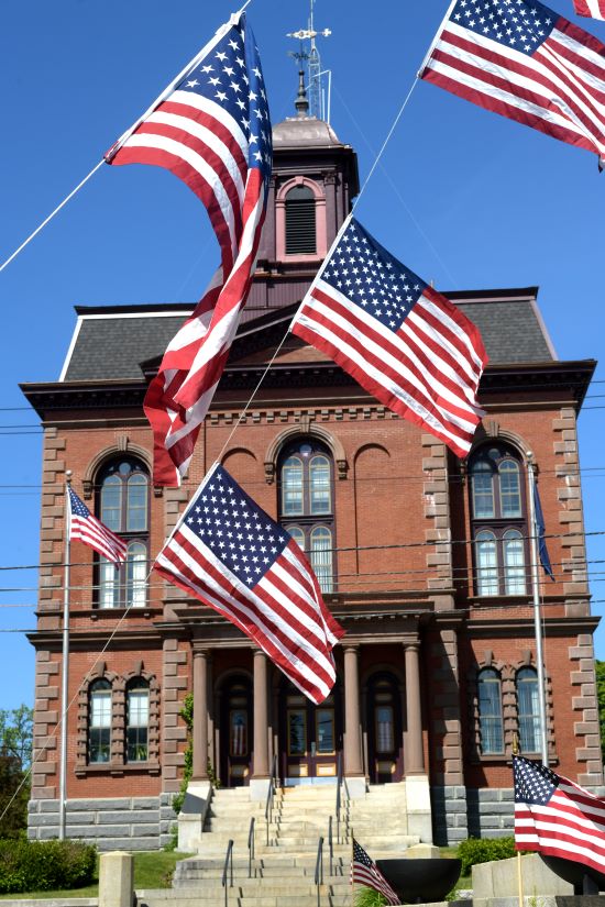 The exterior of the Sagadahoc County office building with many American flags flying. 
