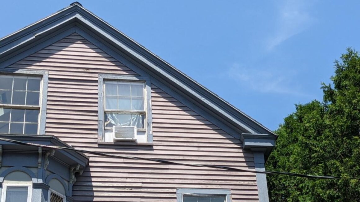 A window unit air conditioner is installed at a house.