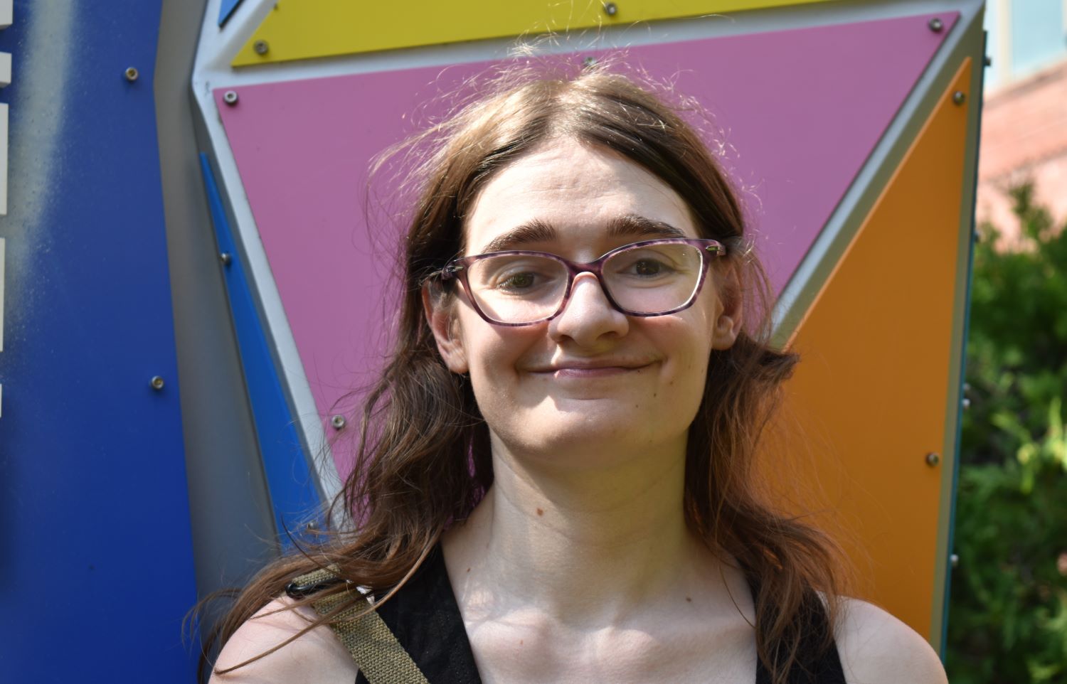 Cindy Thielen poses for a photo against a colorful background.