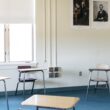 An empty classroom with four desks for students spread out.