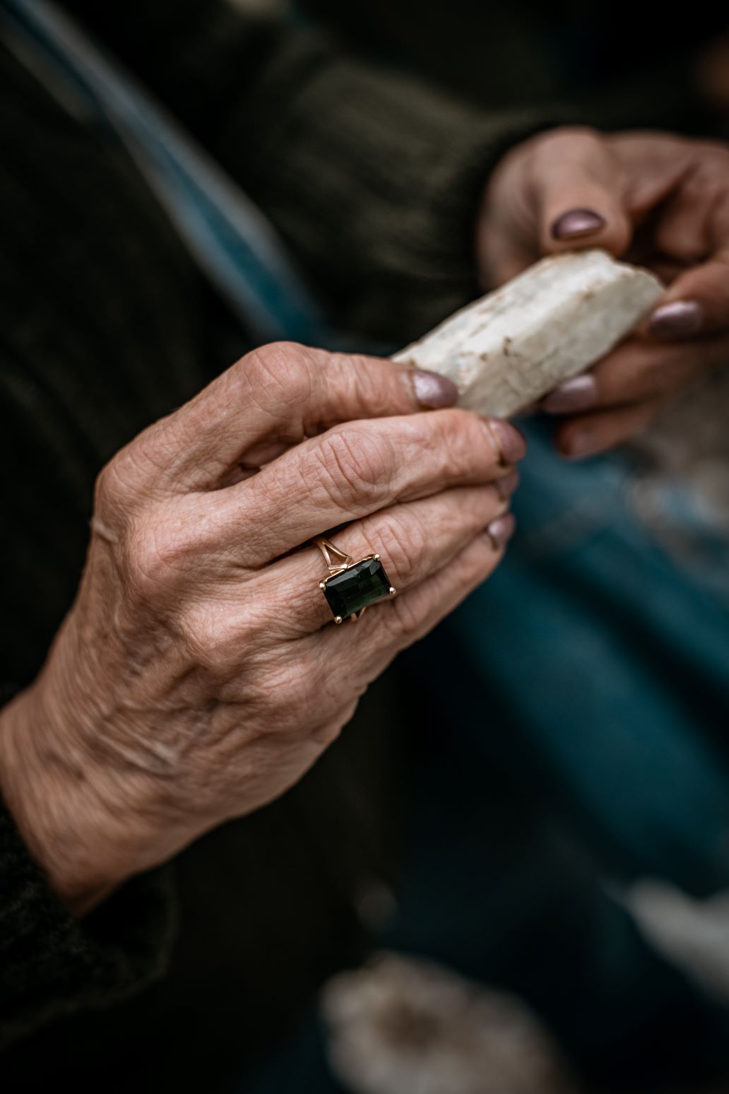 The hands of Mary Freeman hold a spodumene crystal.