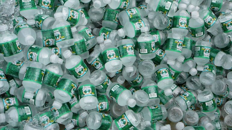 Many small bottles of Poland Spring water.