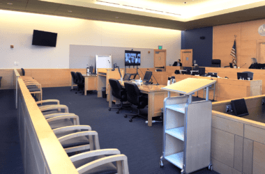 a judge and court clerk in an otherwise empty court room