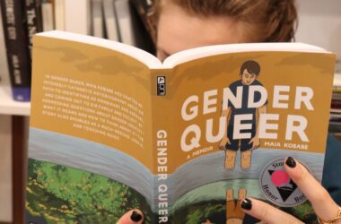 An individual reads the book Gender Queer.