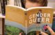 An individual reads the book Gender Queer.