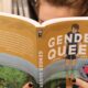 An individual reads the book Gender Queer.
