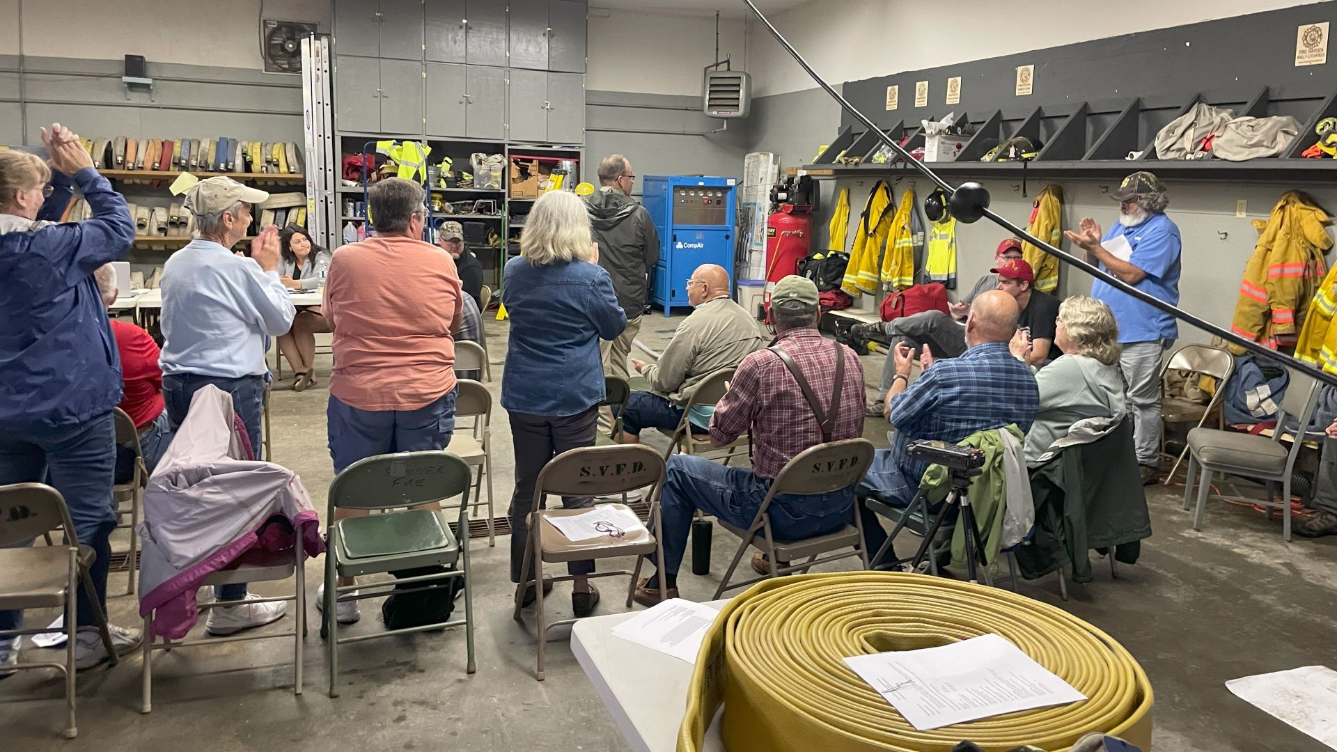 Residents stand during an ovation for firefighters.
