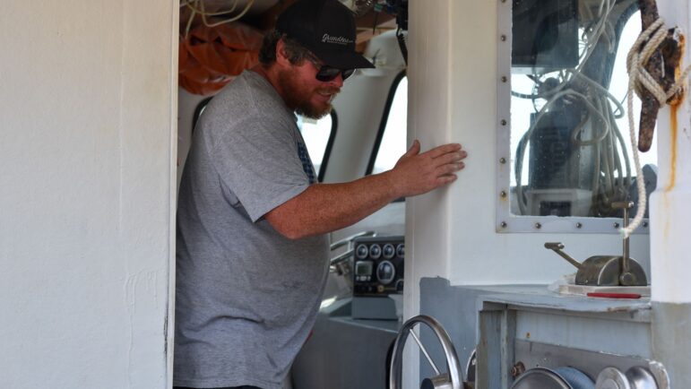 Chris Tobey moves around on his lobster boat.