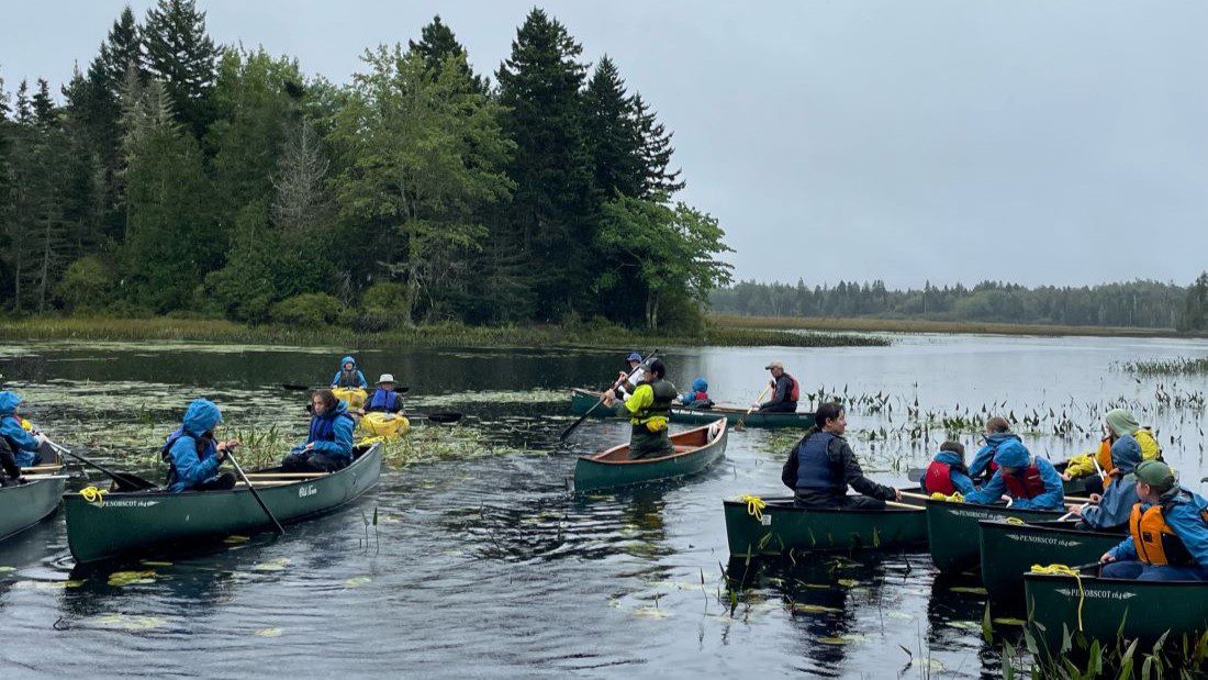 Young people on canoes in Reynolds Brook Marsh near Whiting, Maine.