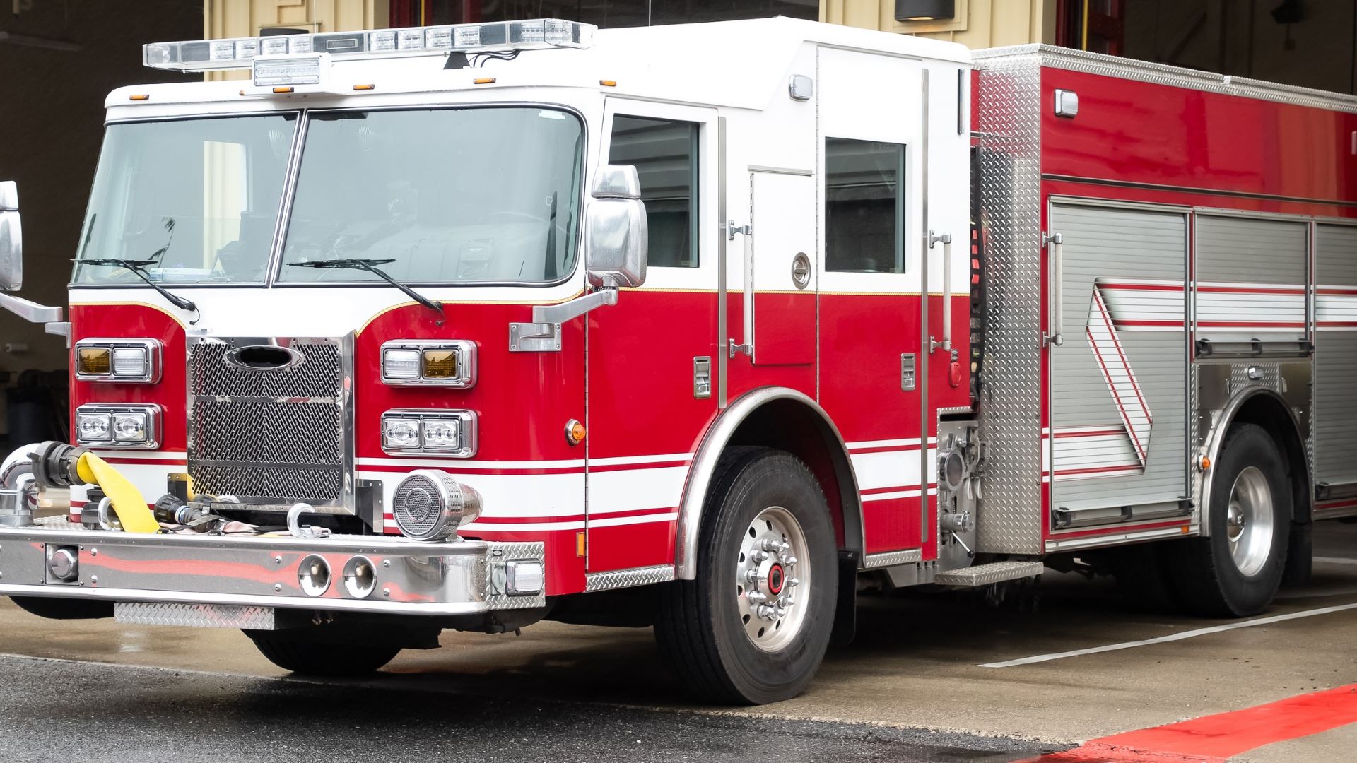 A fire truck sits outside a department bay.