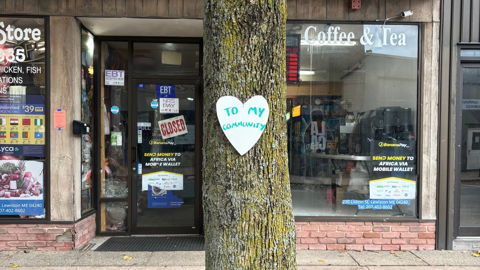 A white paper heart that says to my community is stapled to a tree.