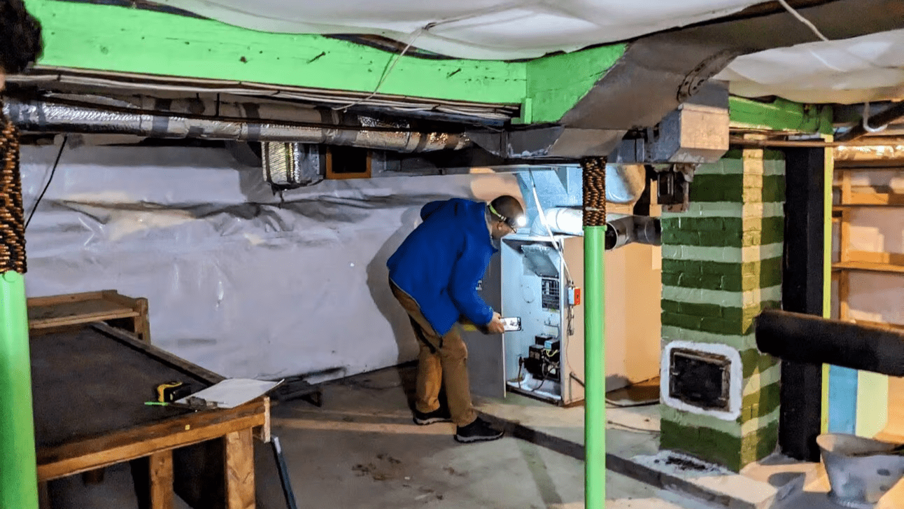 An energy auditor inspects a furnace.