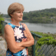 Peggy Schaffer poses for a photo while looking over a river.