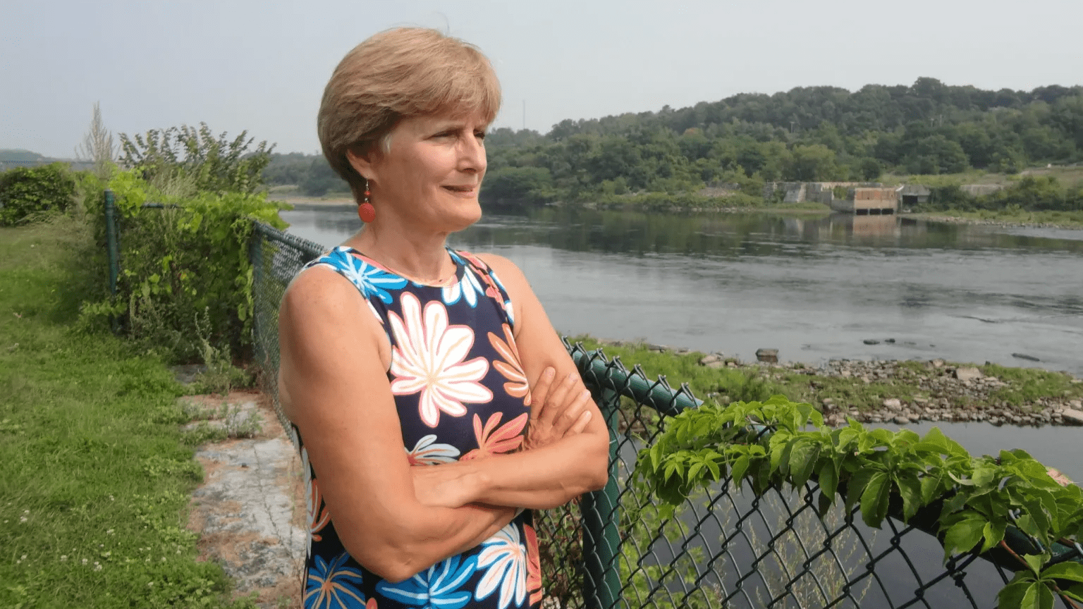 Peggy Schaffer poses for a photo while looking over a river.
