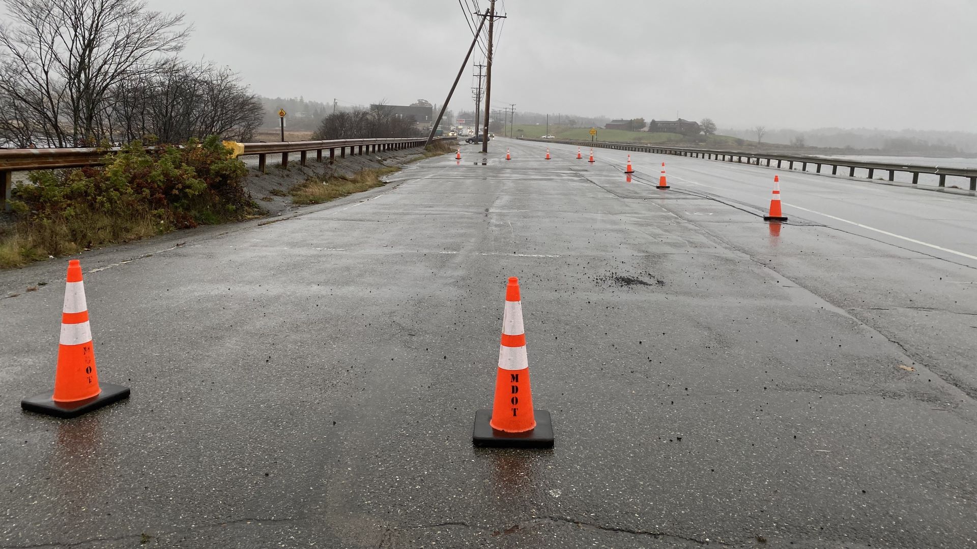 Orange traffic cones placed around deteriorated portions of the dike