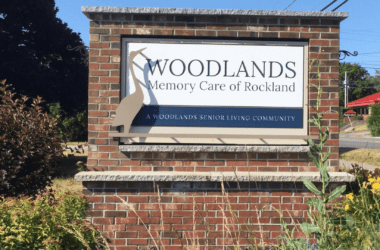 The sign for Woodlands Memory Care of Rockland at the facility's entrance