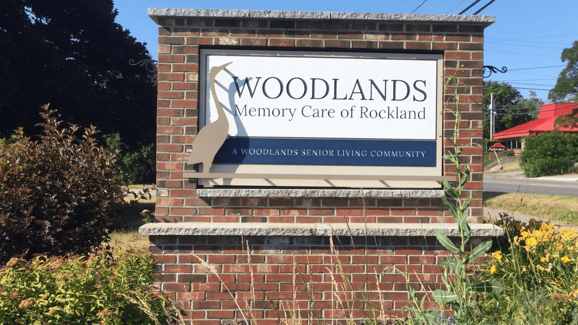 The sign for Woodlands Memory Care of Rockland at the facility's entrance