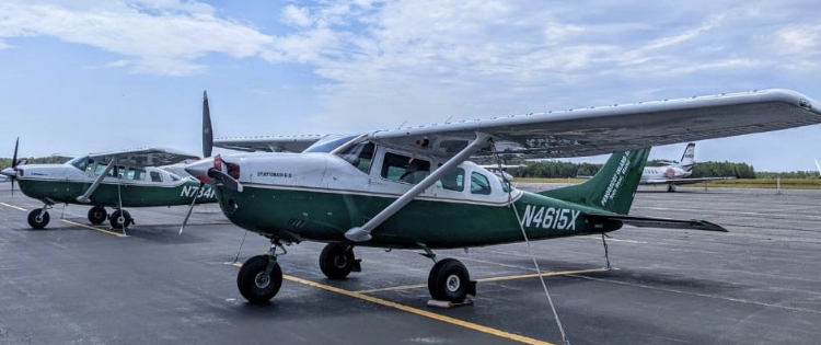Two planes belonging to Penobscot Island Air sit on the tarmac.