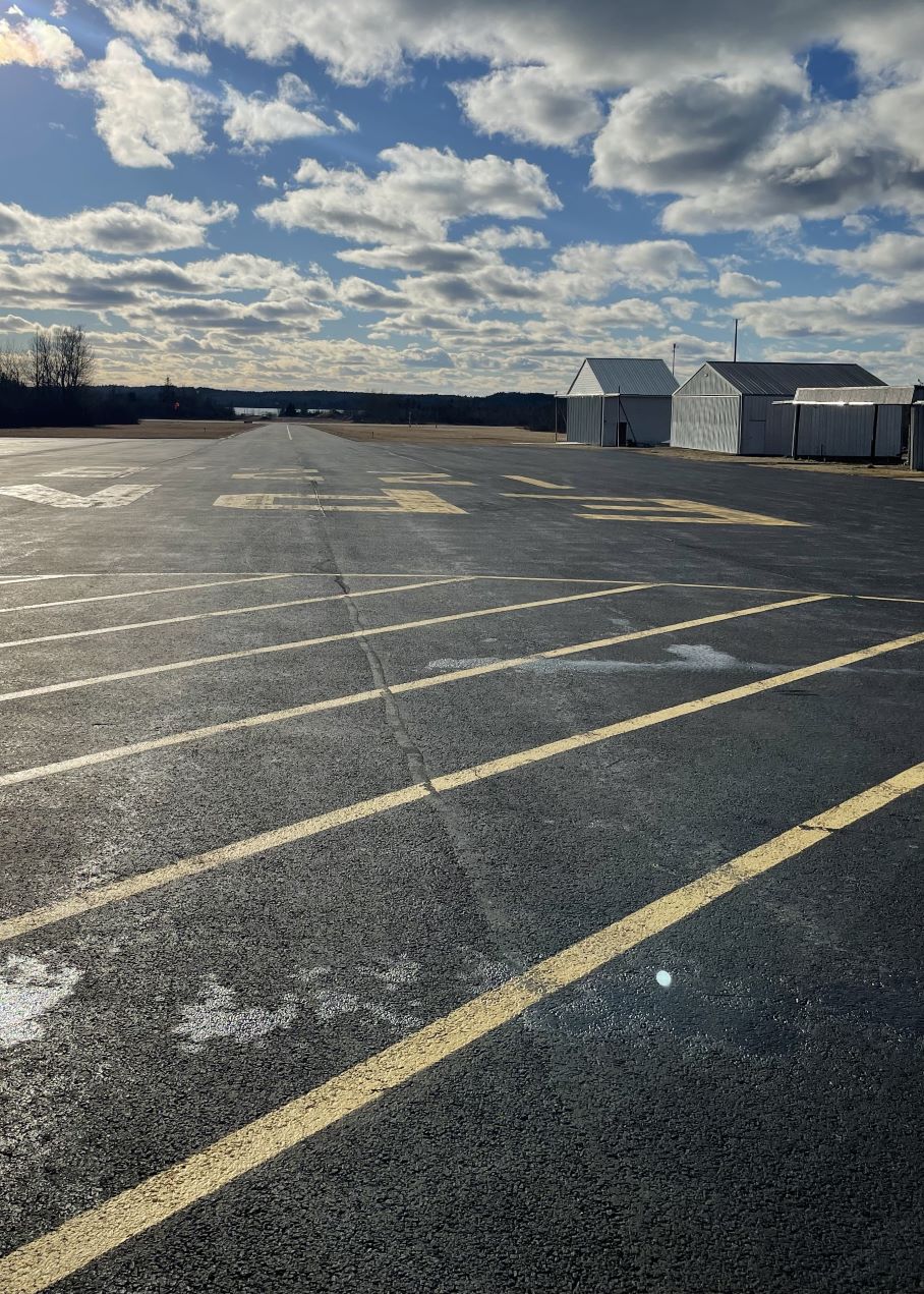 A view of the runway approach at Eastport airport and two hangars.