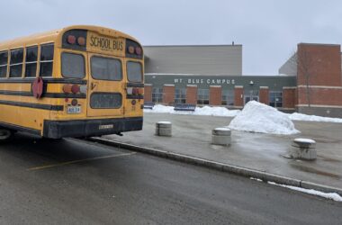 A yellow school bus sits outside the Mt. Blue campus.