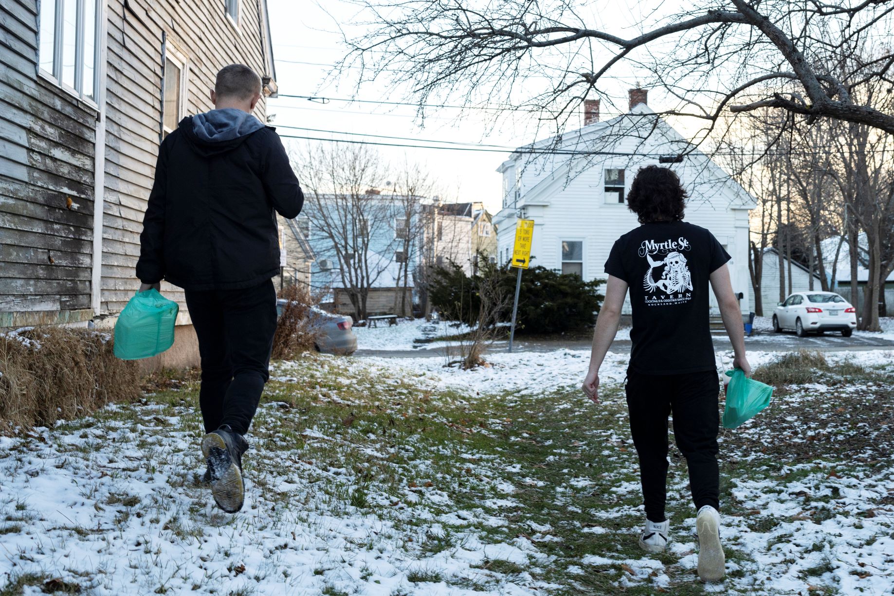 Two teen males walk down a path with their backs to the camera.