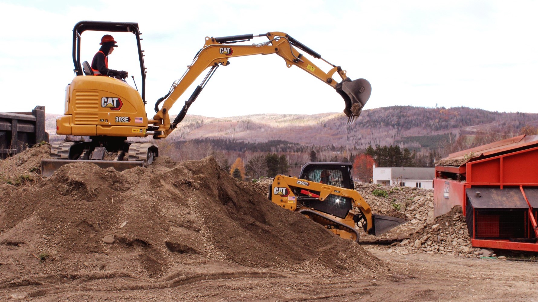 Two pieces of heavy, yellow machinery being operated by students.