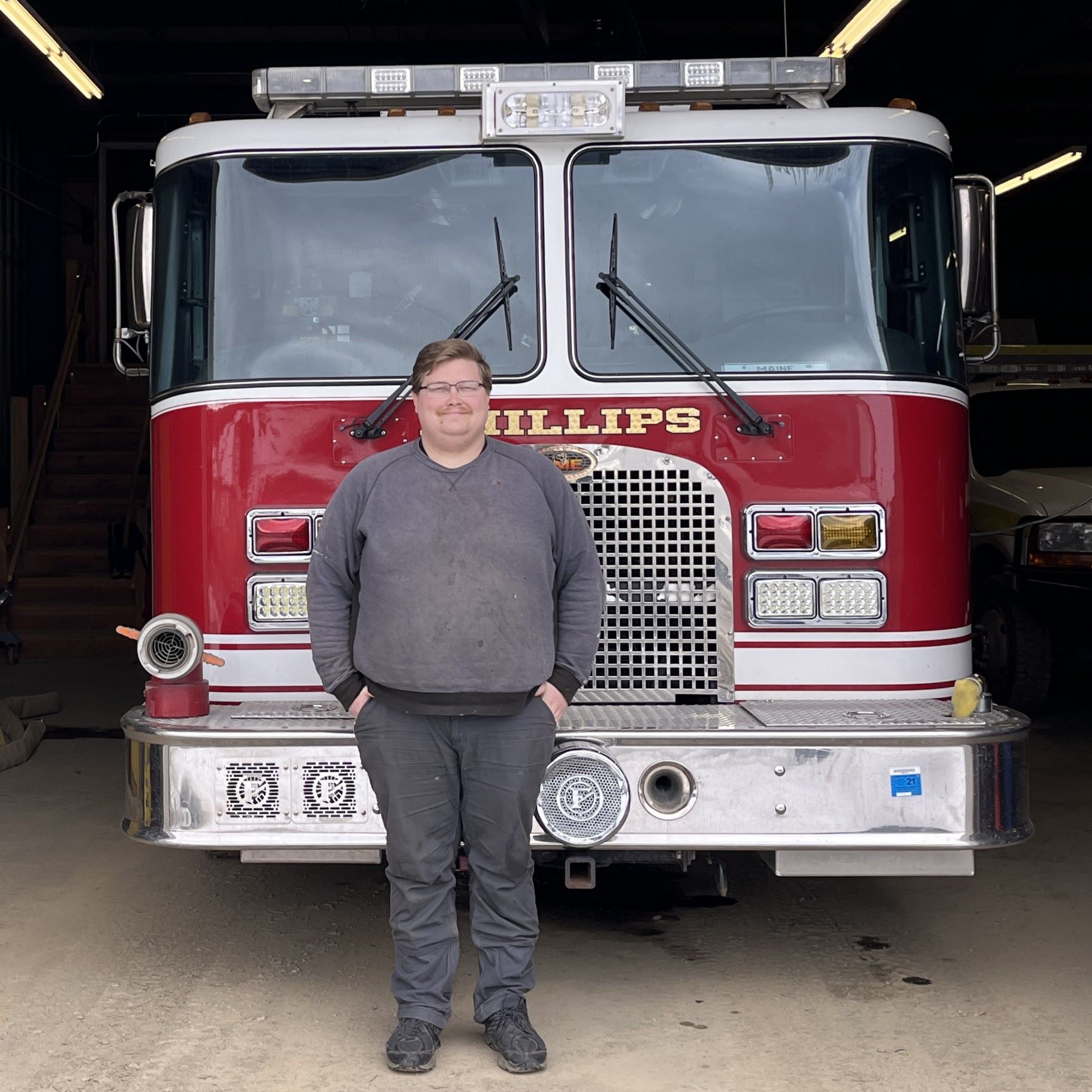 Captain Sean Allen poses for a photo in front of a fire truck.