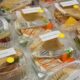 Rows of deli sandwiches packed in to-go containers.