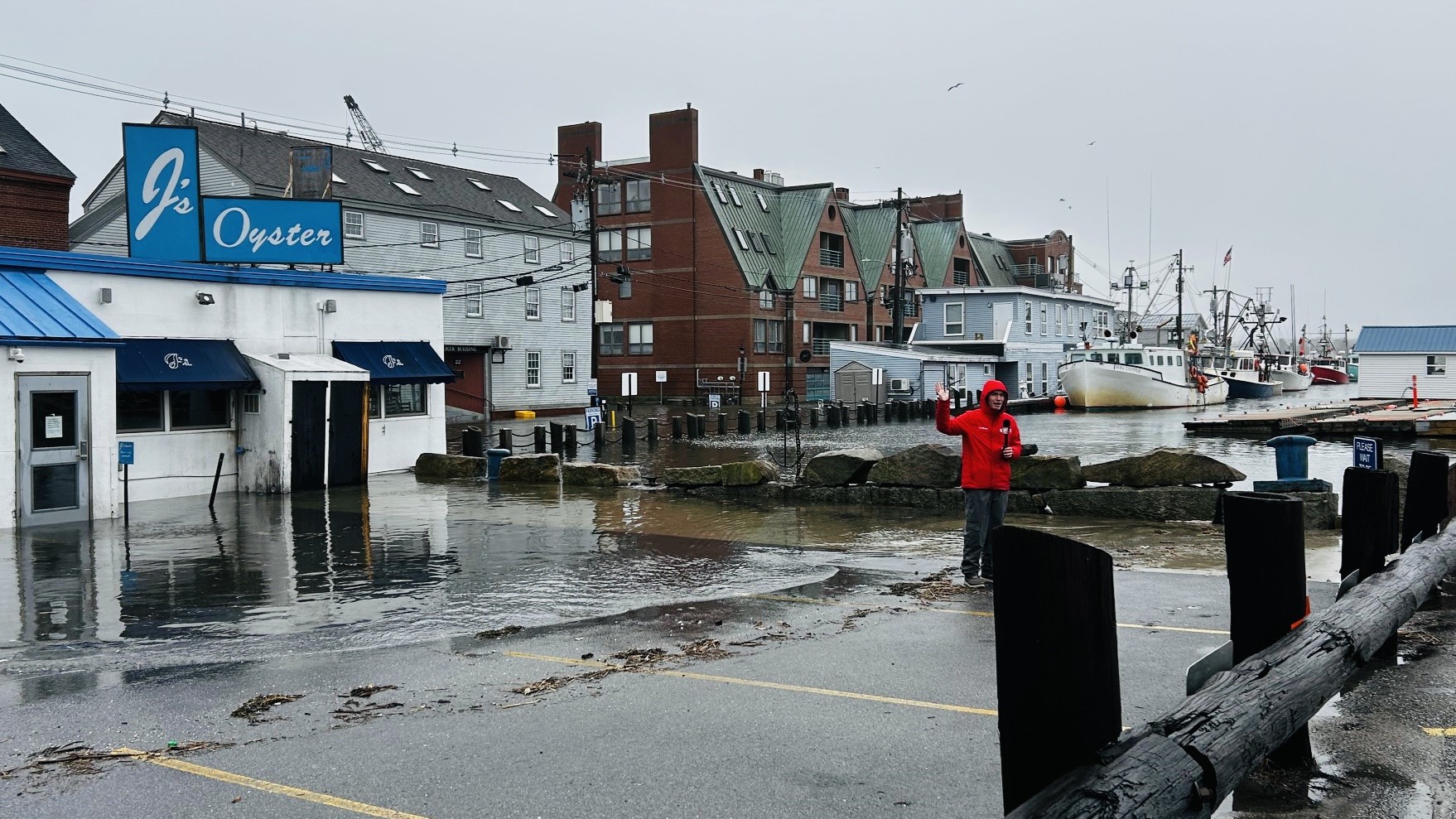A TV news reporter records a segment in the parking lot of J's Oyster as part of the station's coverage of flooding in Portland.