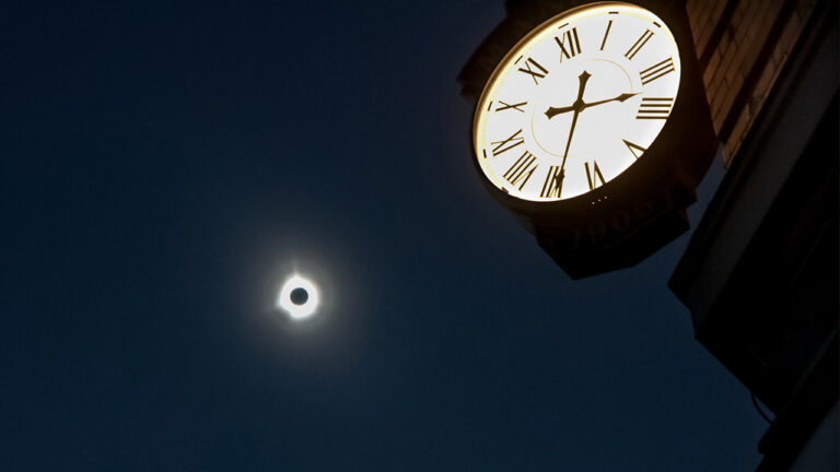 The solar eclipse as seen near a clock in Houlton, Maine.
