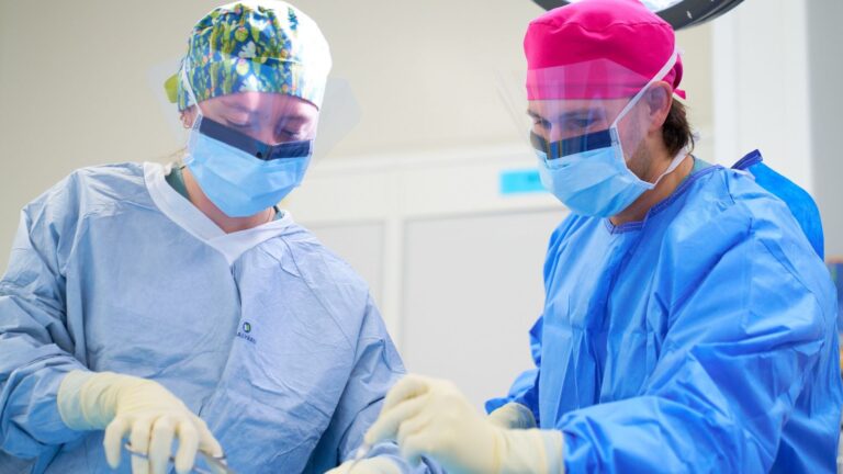 Two surgeons participate in an operating room exercise.