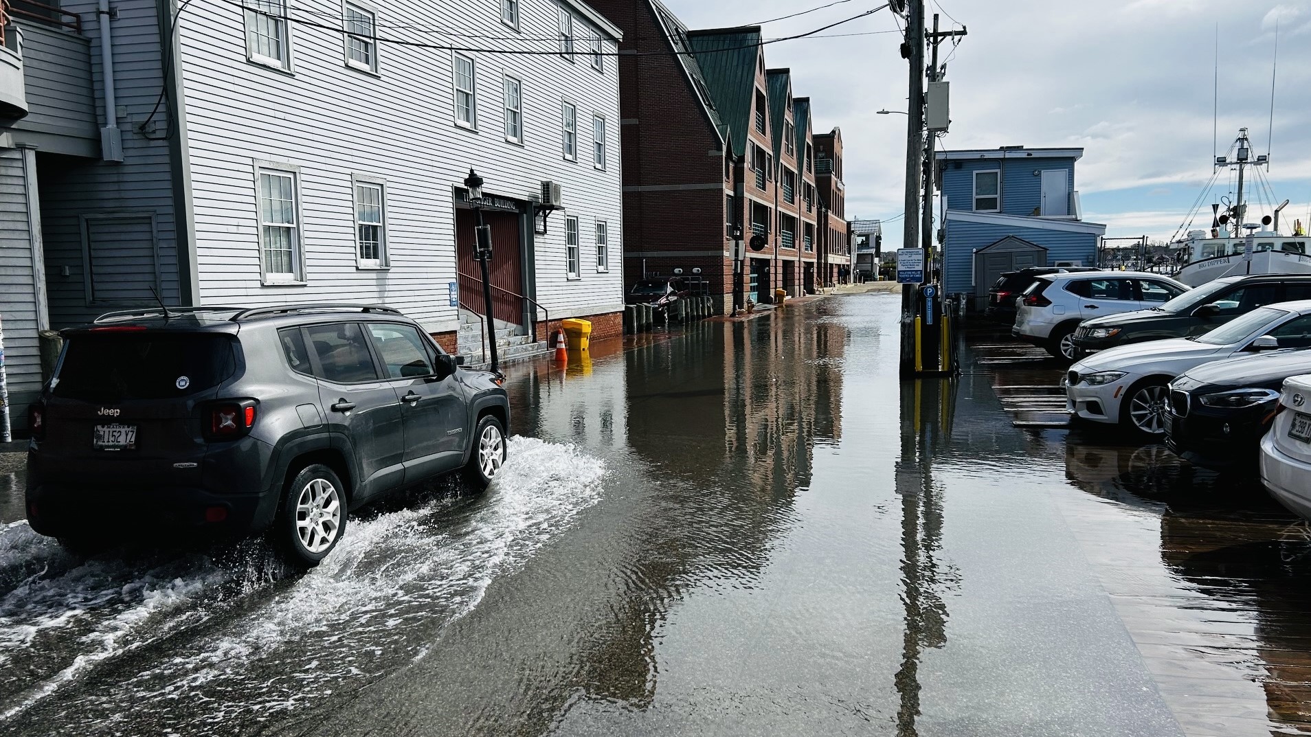 A car drives through a flooded Portland street.