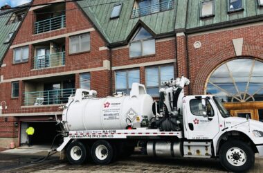 A water pump truck outside of a condo building.