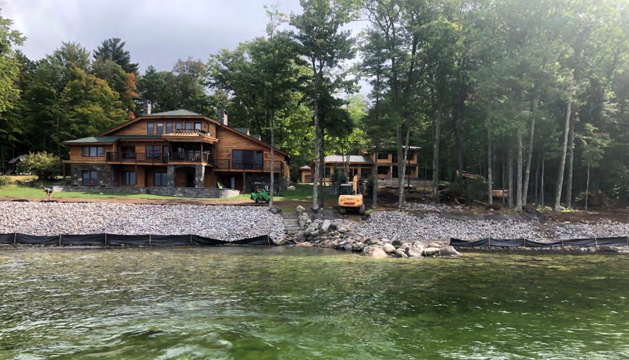 Workers at work by the shoreline of a property in Raymond.