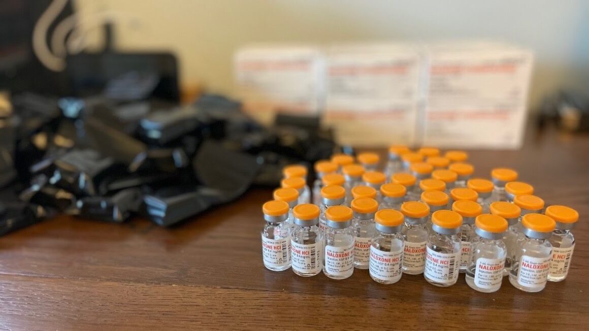 Bottles of intramuscular naloxone sit on a table.