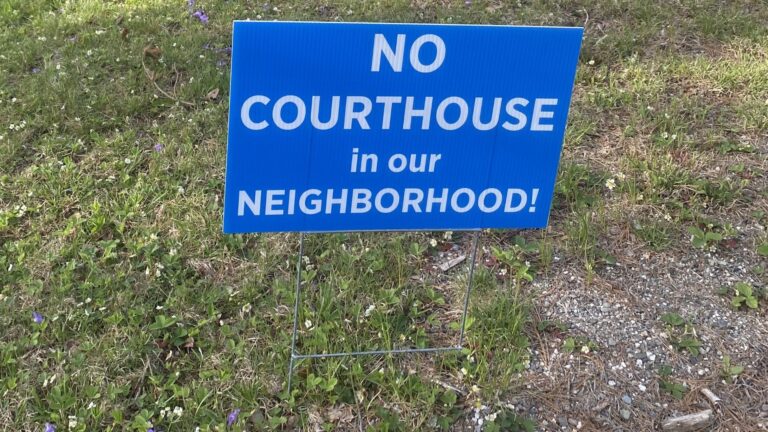 A blue yard sign that reads no court house in our neighborhood.