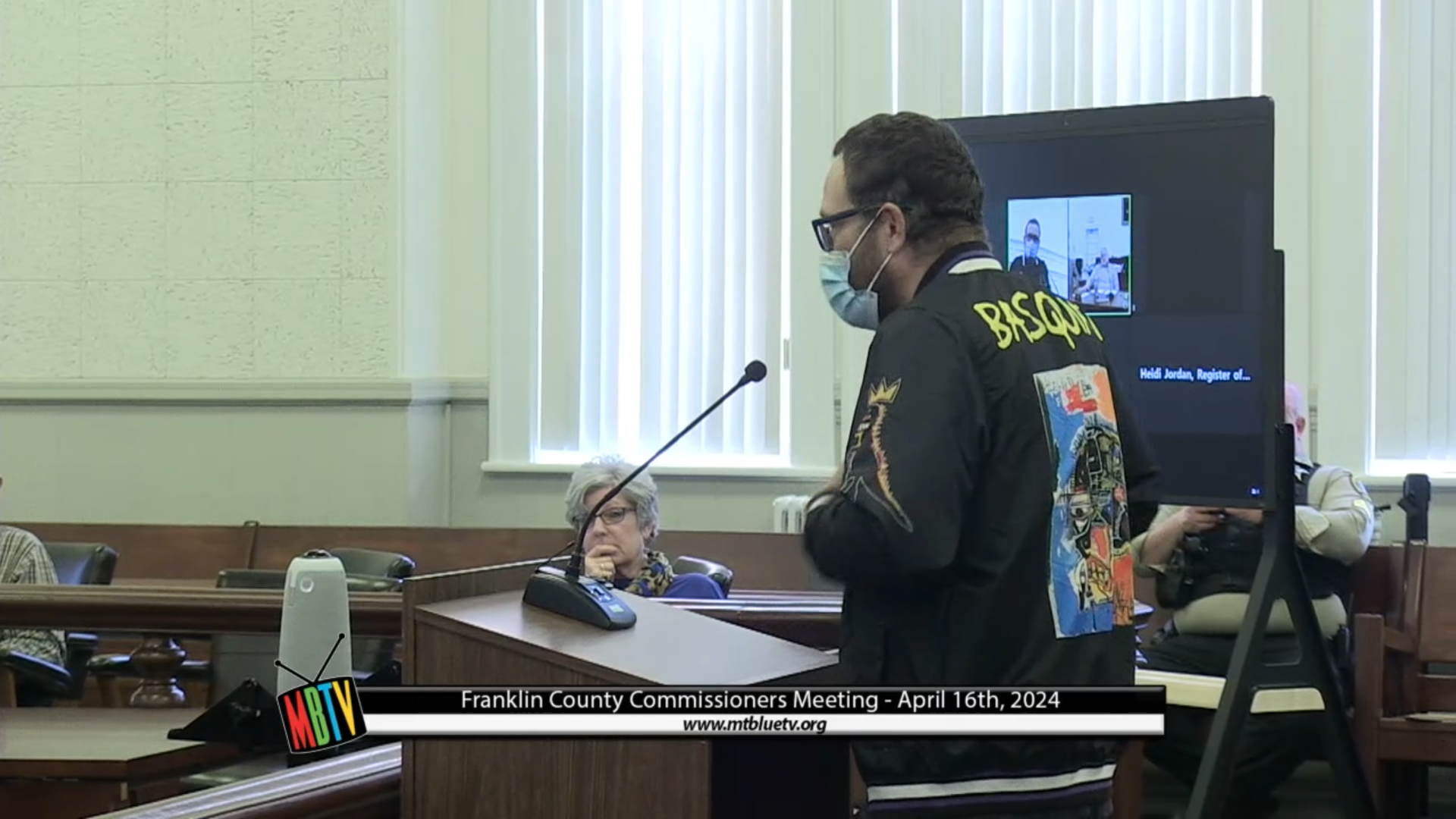 Keith Amato speaks while standing at a podium during a commission meeting.